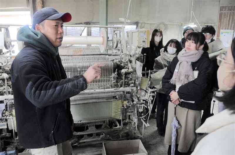 畳表の生産について説明を受ける学生と九州農政局の若手職員＝12日、八代市