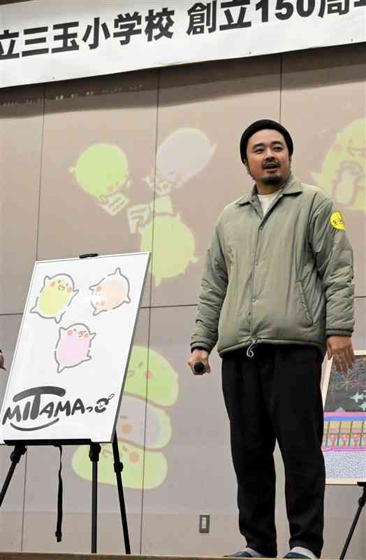 記念キャラクターを紹介するマンガ家の飛松良輔さん＝15日、山鹿市