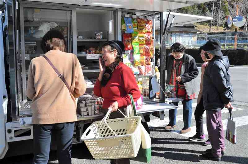 ゆめマート熊本が運行する移動販売車が到着し、談笑しながら買い物をする住民ら＝1月18日、山都町今