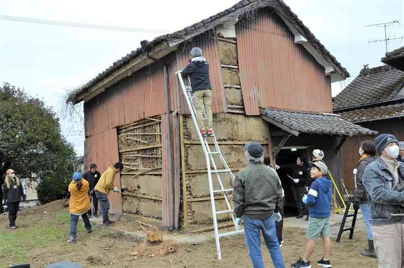 古い土蔵の土壁を観察する参加者ら＝15日、美里町