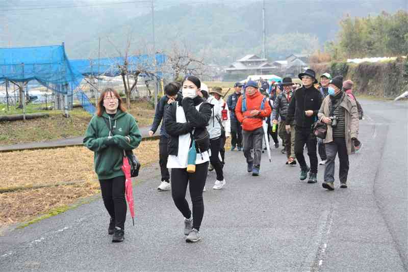 内野小児童が開発に携わったフットパスコースを歩く参加者＝16日、芦北町