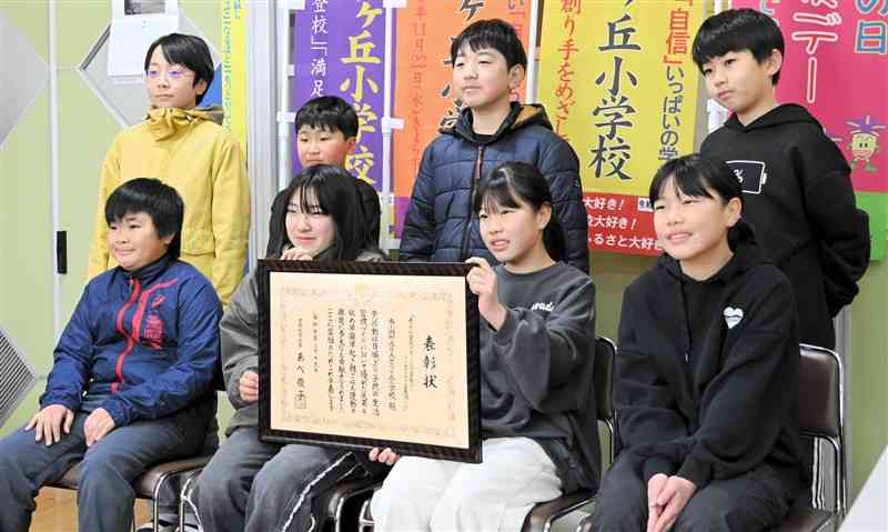 代表して表彰状を掲げ、記念撮影するりんどうケ丘小の5年生＝21日、南小国町