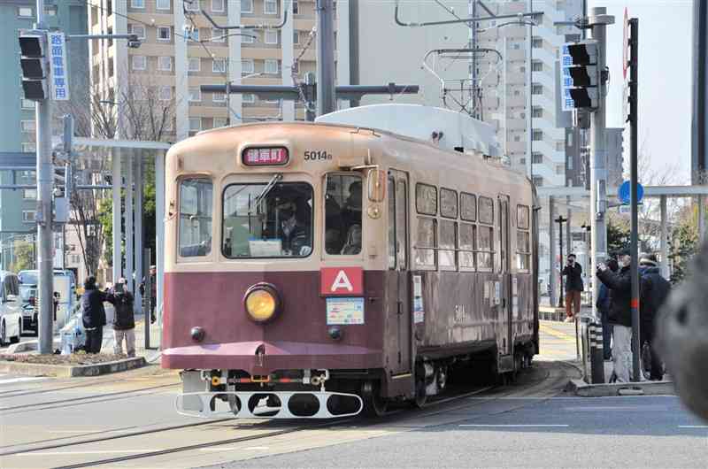 運行最終日に快走する熊本市電の5014号車＝22日、JR熊本駅前