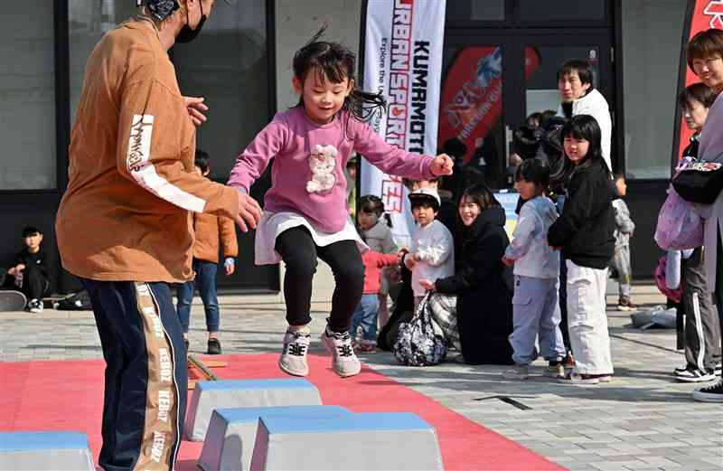 「KUMAMOTO　URBAN　SPORTS　FES　2025」でパルクールを体験する来場者＝22日午前、菊陽町総合体育館（上杉勇太）